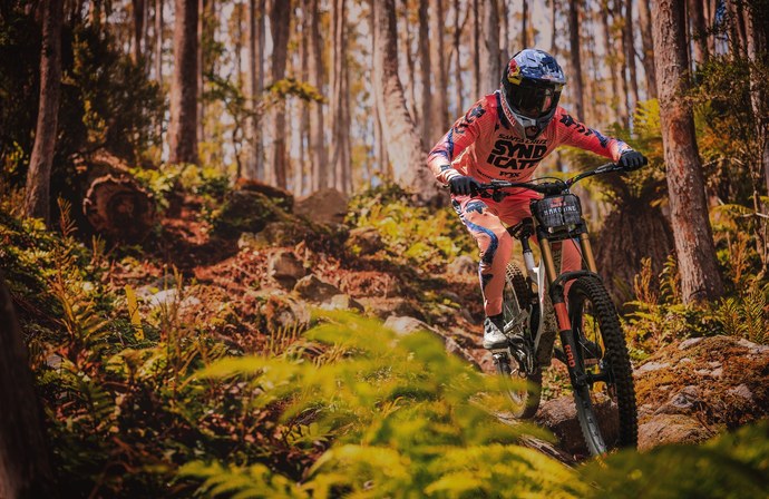 Jezdec FOX při downhillové jízdě na lesním trailu